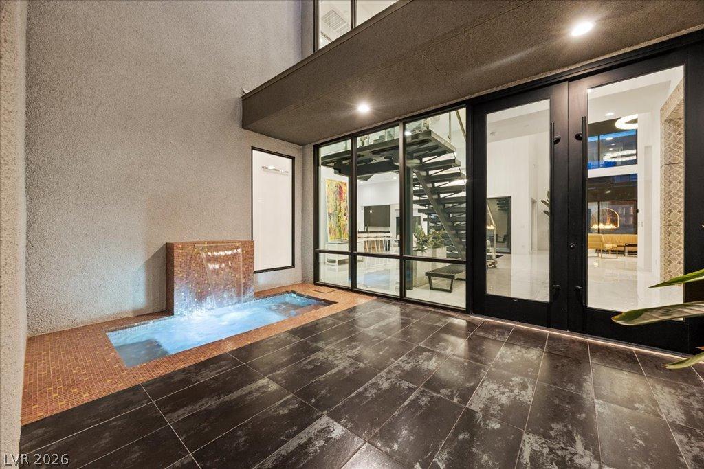 Image 4: An inviting water feature and sleek glass doors le