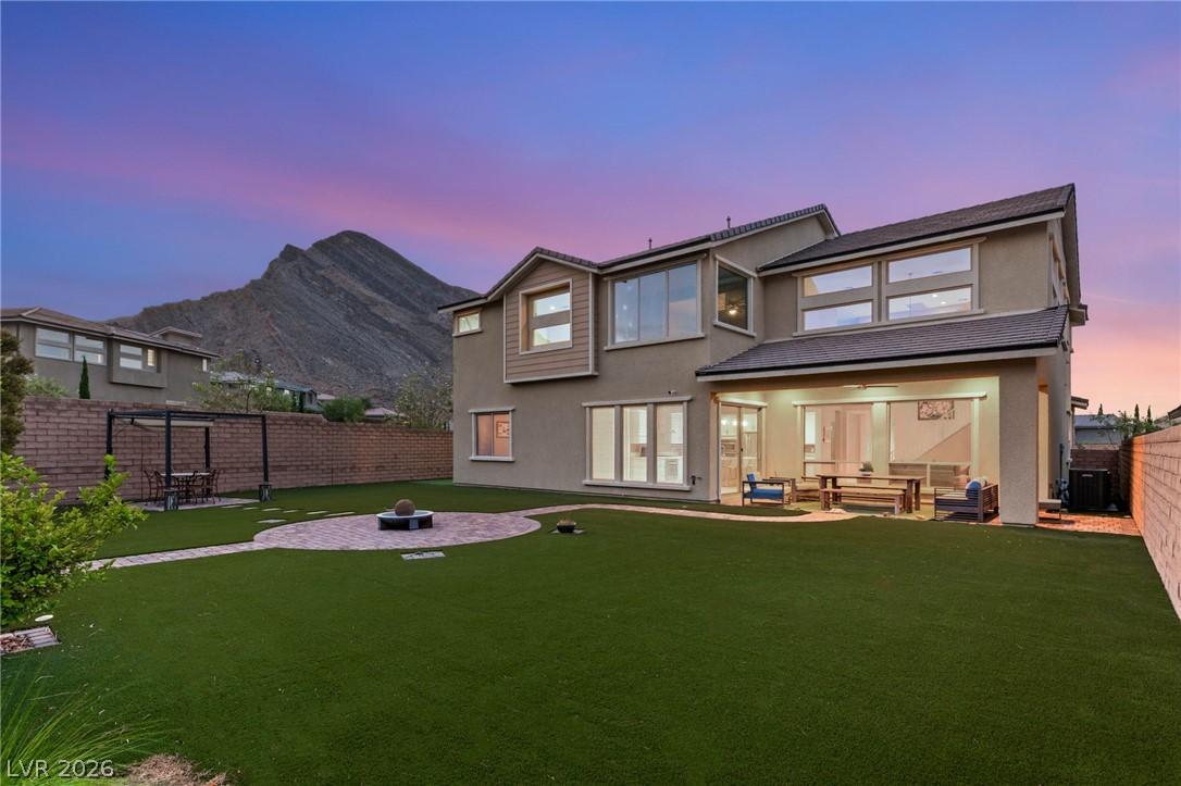 Image 4: A spacious backyard features a fire pit and covere