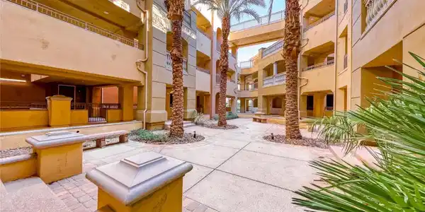 Image 3: Palm trees shade a paved multi-level courtyard bor