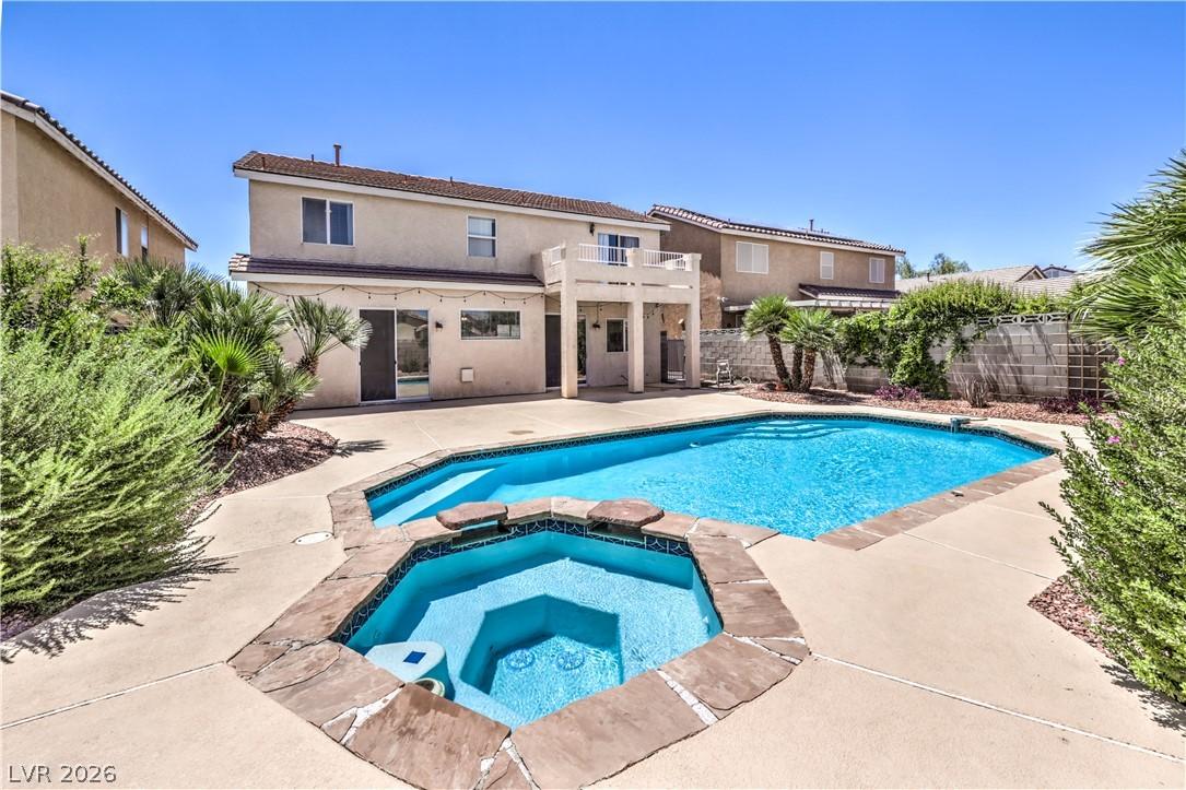 Image 2: An inviting pool and spa beckon in this private ba