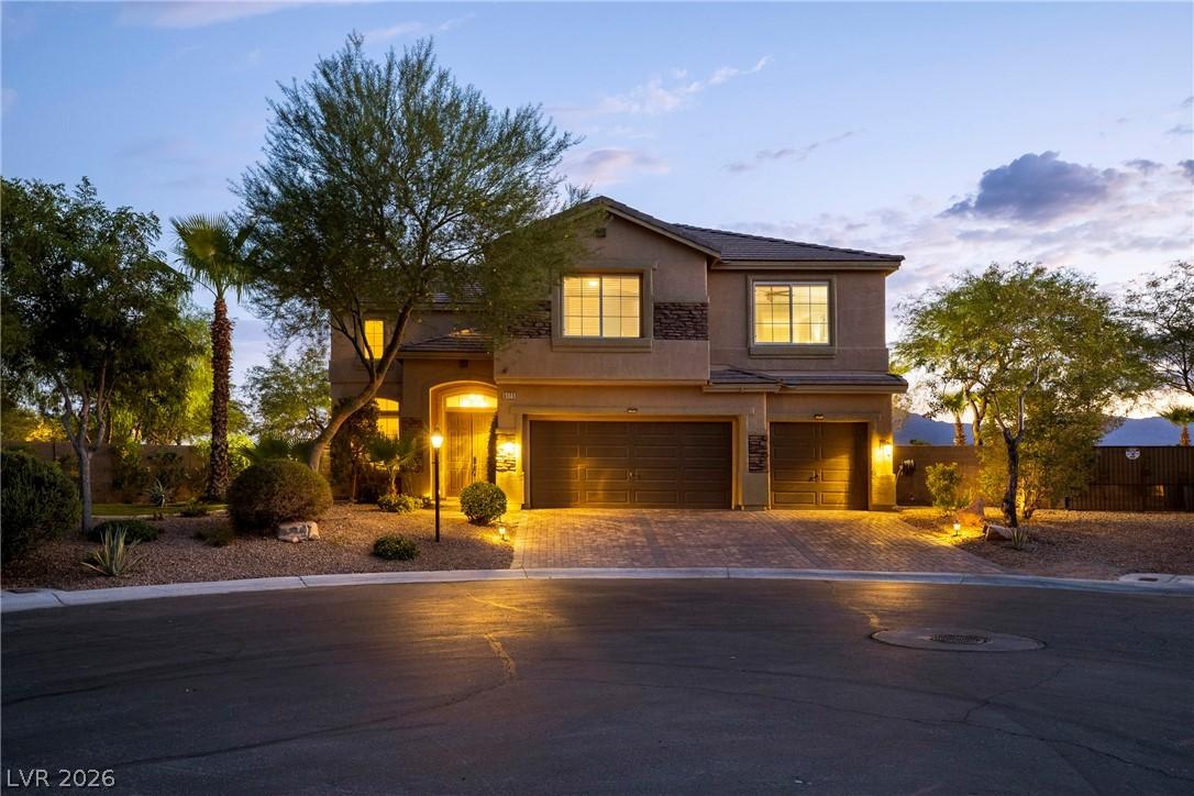 Image 3: Illuminated entryway and attached garage doors enh