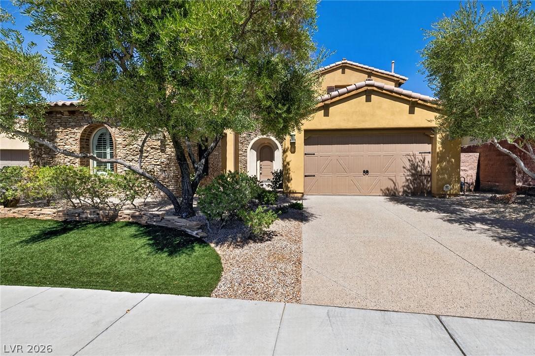Image 4: A welcoming stone facade home features an arched e