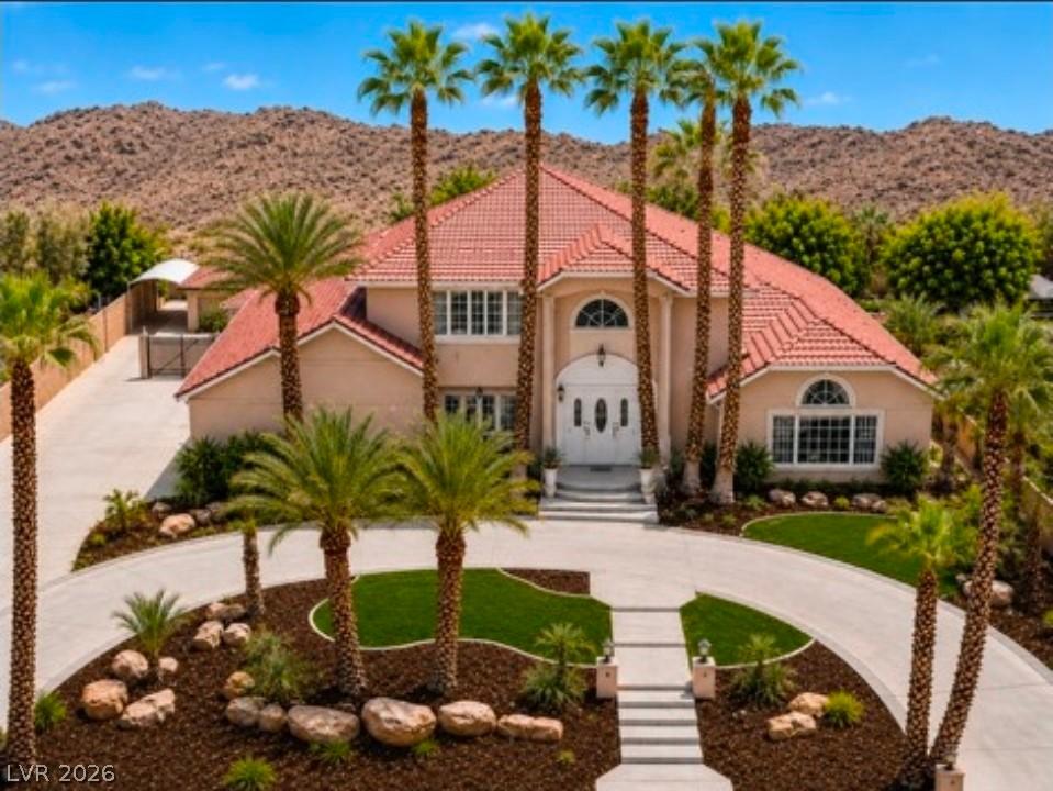 Image 2: A grand entrance with mature palm trees frames thi