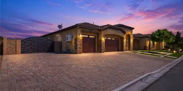 Image 2: An inviting exterior with a brick paver driveway a