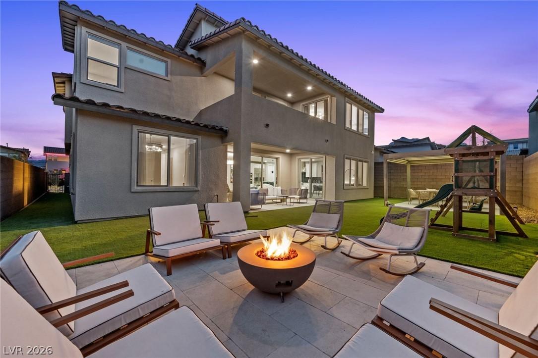Image 2: An inviting backyard oasis features a fire pit, pa