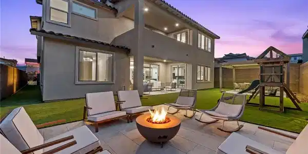 Image 2: An inviting backyard oasis features a fire pit, pa