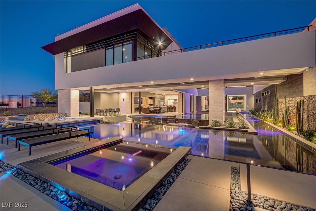 Image 1: Pool at twilight featuring an outdoor pool, a pati