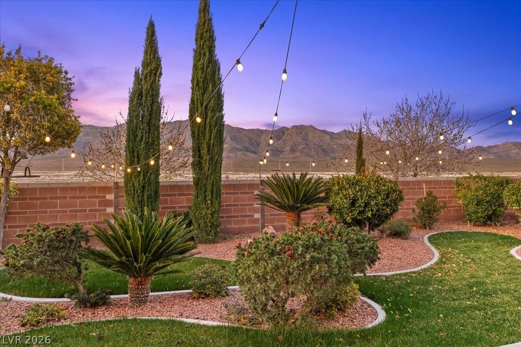 Image 3: The yard blends curated greenery with curved, well