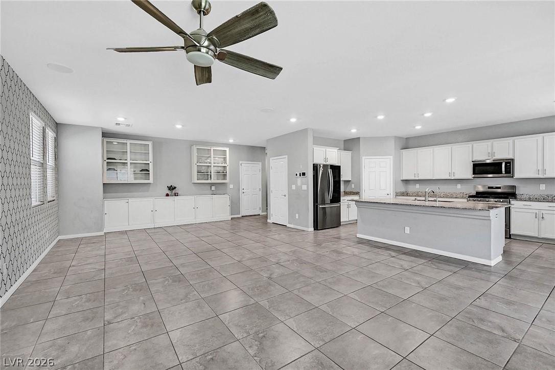 Image 3: An open-concept living area boasts a modern kitche