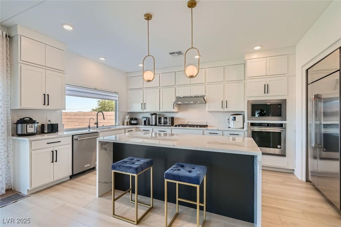 Image 1: Kitchen featuring light stone countertops, built i