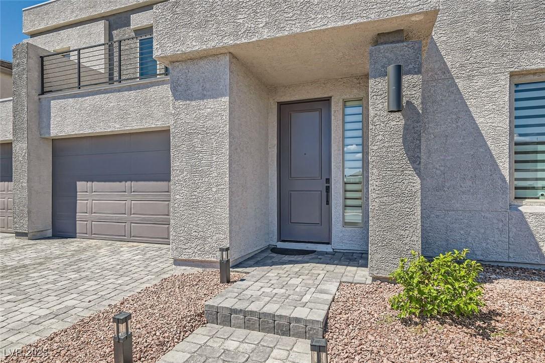 Image 4: Property entrance with stucco siding and a garage