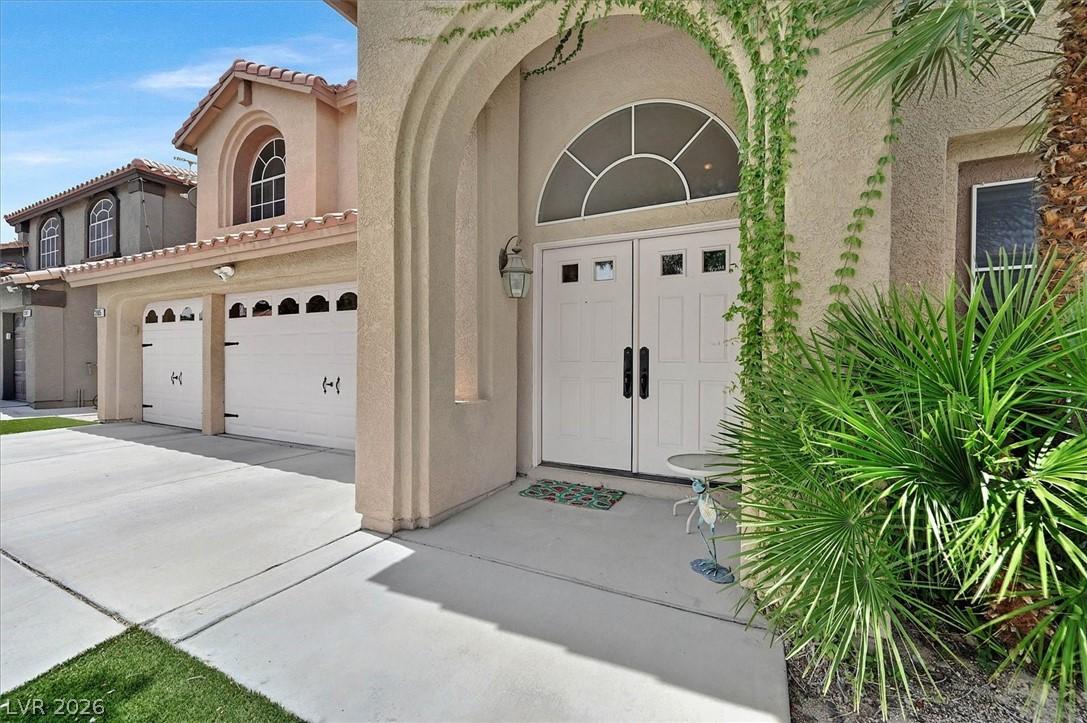 Image 2: Double garage doors flank a grand arched entryway