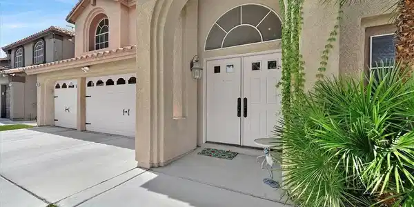 Image 2: Double garage doors flank a grand arched entryway