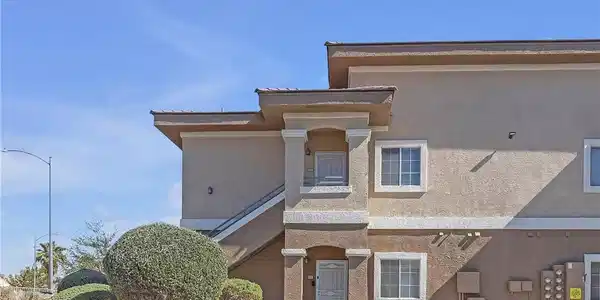 Image 2: A neatly maintained exterior with mature shrubs, s