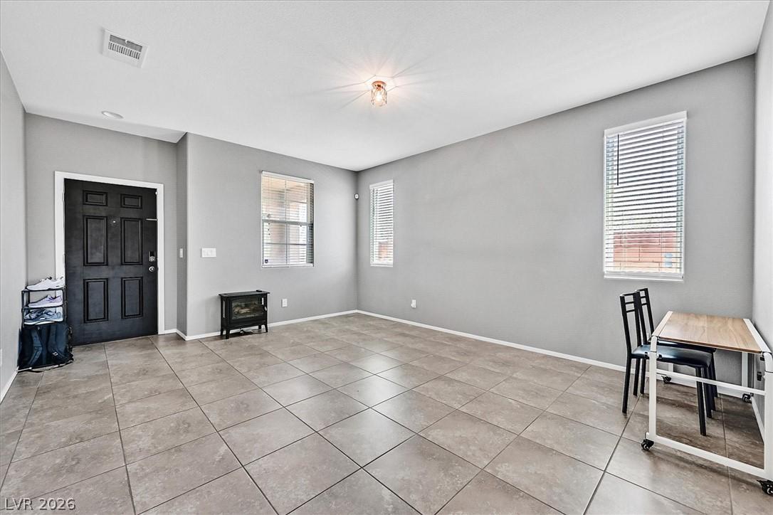 Image 3: A well-lit room with tile flooring and multiple wi