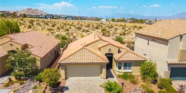 Image 2: An inviting tiled roof home with a paver driveway,