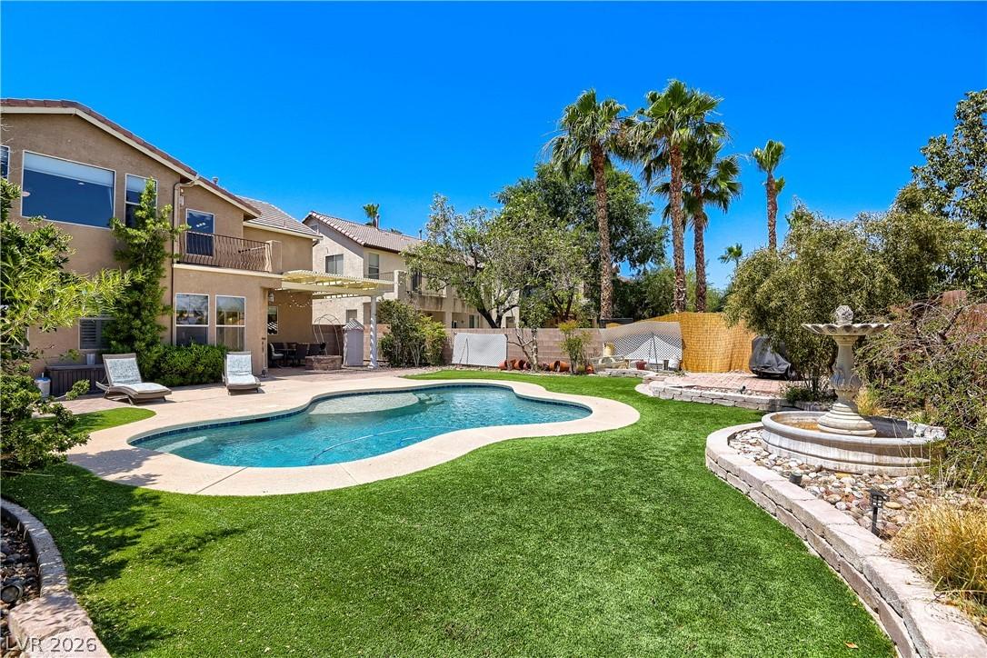 Image 2: A tranquil backyard oasis features a freeform pool