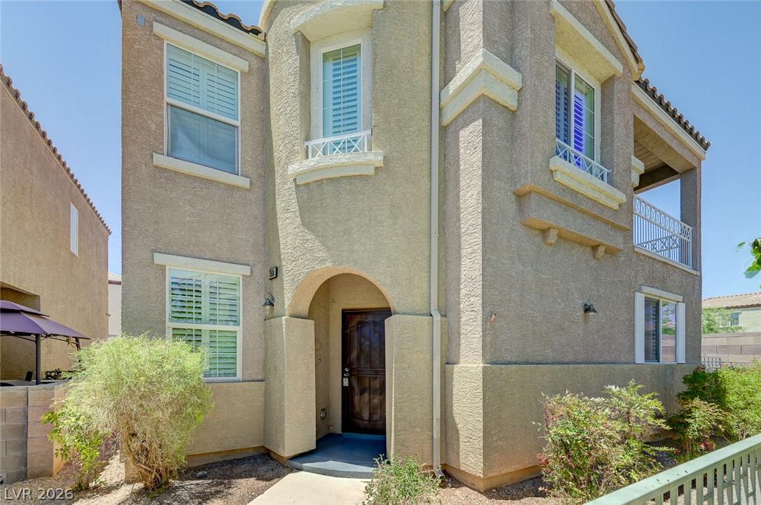 Image 1: A charming stucco exterior welcomes with an arched