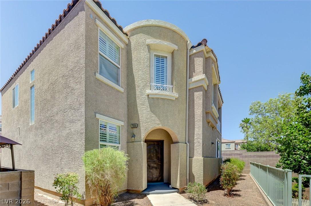 Image 2: A charming stucco exterior welcomes with an arched