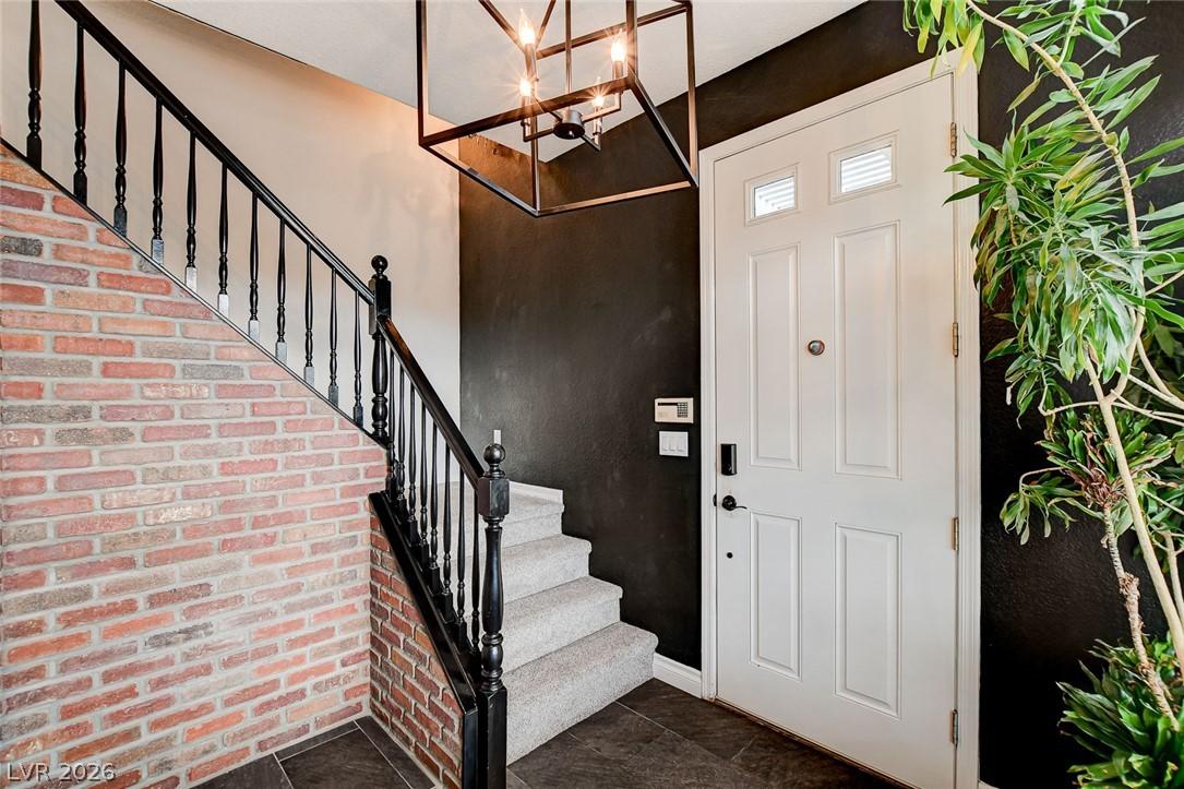 Image 4: A striking entry features a brick accent wall and