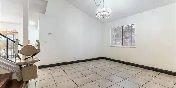 Image 3: A vaulted ceiling and tile floors define this open