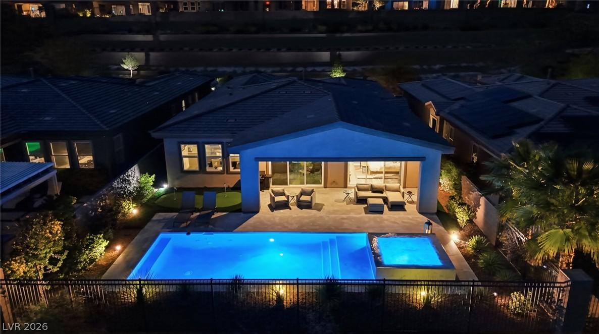 Image 3: An inviting backyard oasis offers a luminous pool