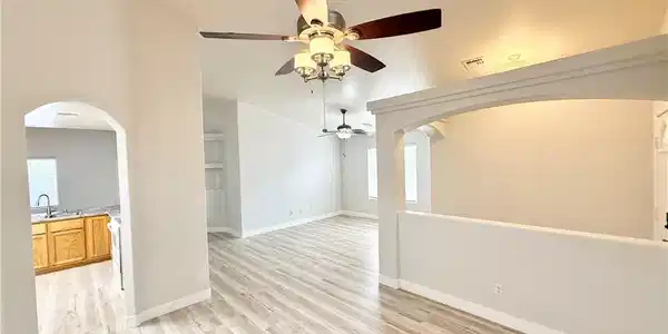 Image 4: An open floorplan with vaulted ceilings and wood-l