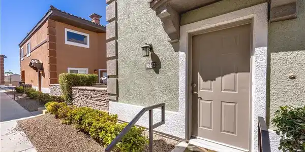 Image 3: Textured stucco walls and concrete walkways define