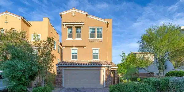 Image 2: This residence showcases a paved driveway and matu
