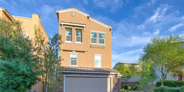 Image 3: This residence showcases a clean stucco exterior w