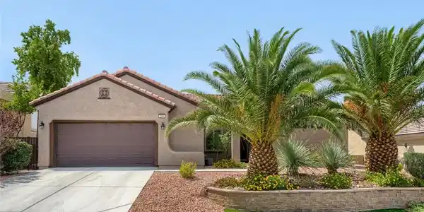 Image 3: Lush palm trees frame this single-story stucco hom