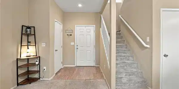 Image 3: A welcoming entryway transitions into carpeted sta