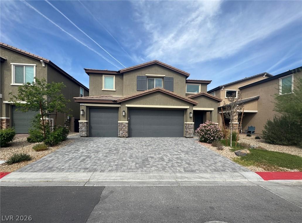 Image 1: A welcoming facade with a stone-accented garage an