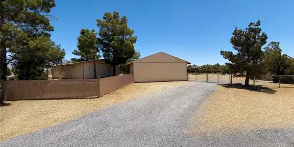 Image 2: A sprawling gravel driveway leads to a secluded pr