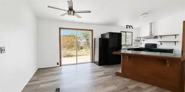 Image 4: A combined living and kitchen area features wood-l