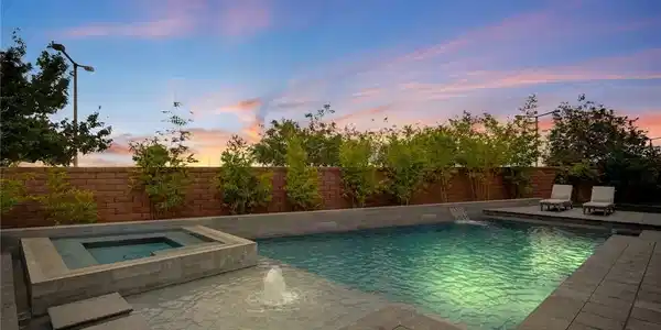 Image 3: An inviting swimming pool and spa are set against