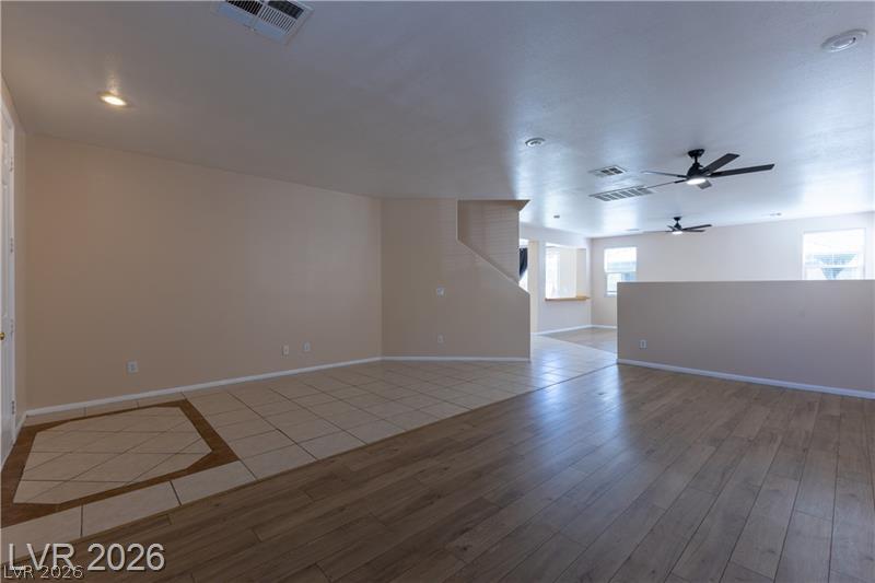 Image 3: A well-lit living area features diverse flooring a