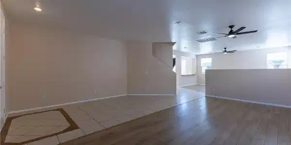 Image 3: A well-lit living area features diverse flooring a