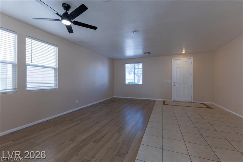 Image 4: A versatile living area with a ceiling fan, plank