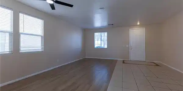 Image 4: A versatile living area with a ceiling fan, plank