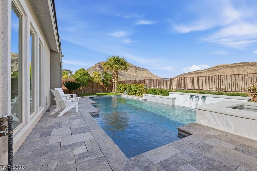 Image 1: Relaxing pool / spa featuring a patio and a fenced