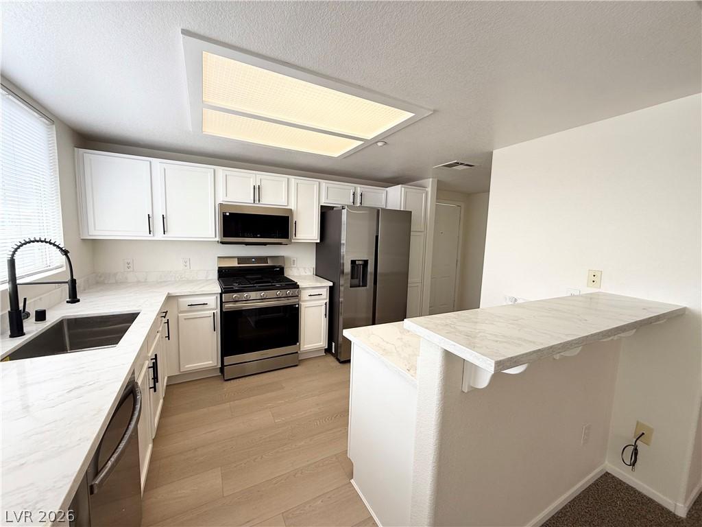 Image 3: This modern kitchen features gleaming countertops,