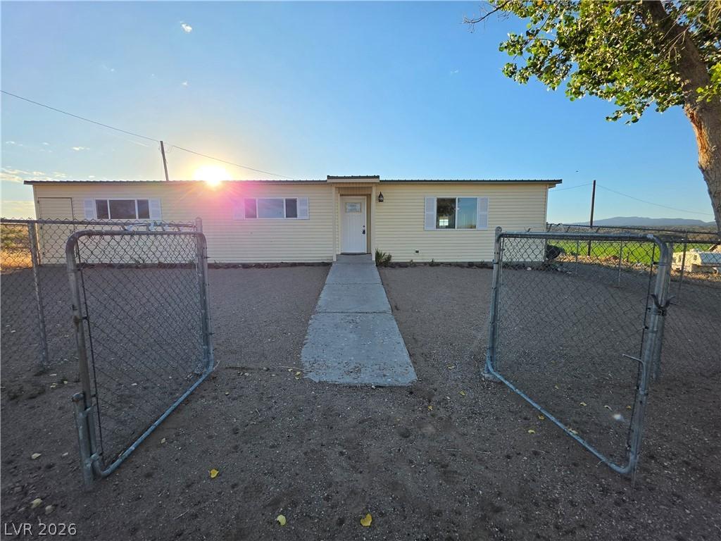 Image 2: A quaint residence sits amidst a spacious, fenced