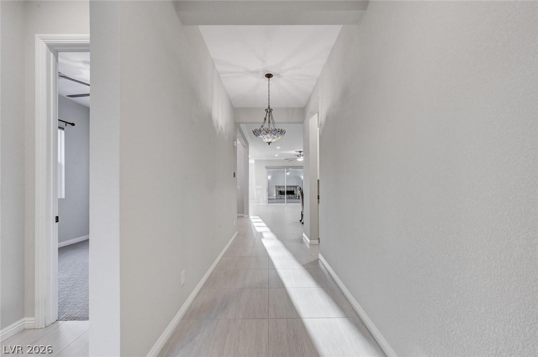 Image 2: A well-lit hallway with elegant tile flooring lead