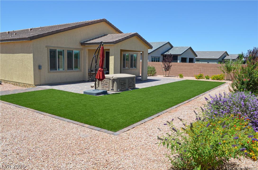 Image 2: A private backyard oasis features artificial turf,