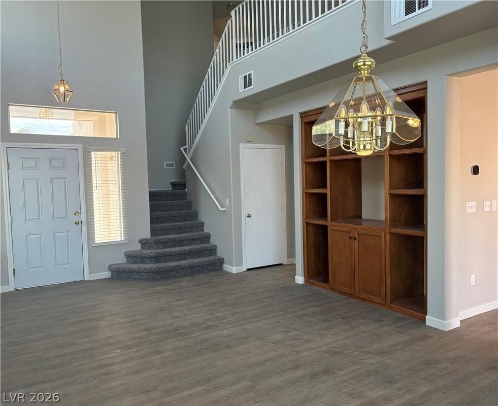 Image 2: A well-lit entry with soaring ceilings, a prominen