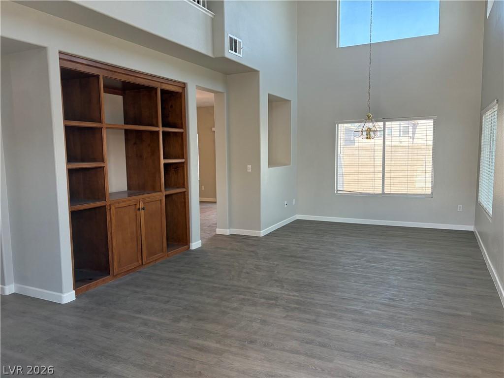 Image 3: A built-in bookcase and high ceilings elevate this