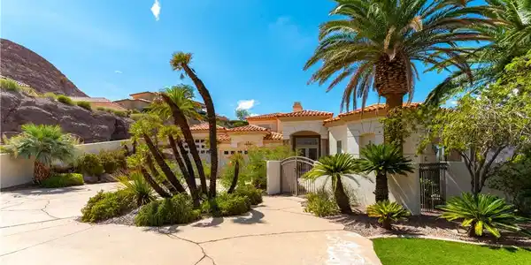 Image 2: Lush palm trees frame the welcoming entrance and g