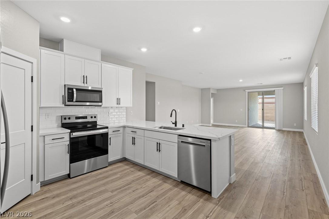 Image 4: A contemporary open-concept kitchen with crisp whi