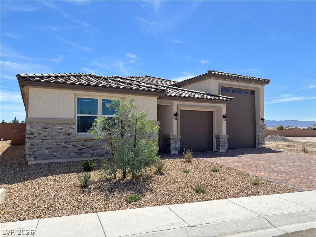 Image 2: View of front of home featuring stone siding, stuc